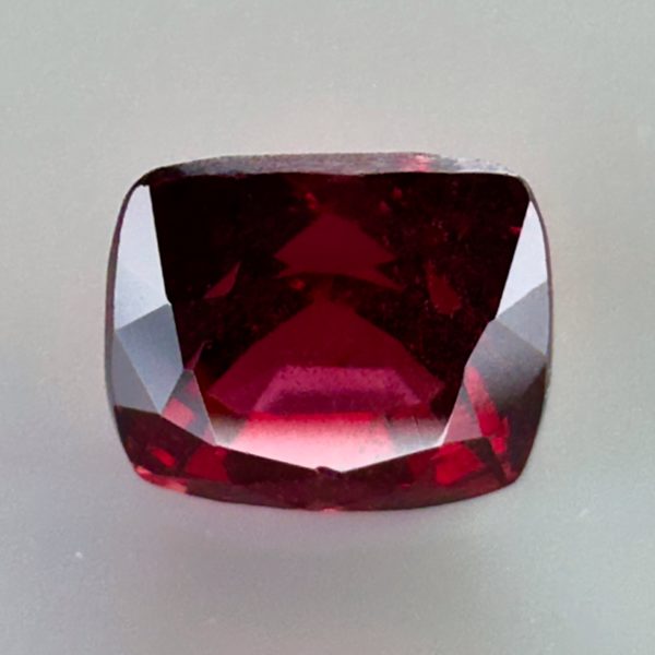 Natural cushion cut red spinel from Burma, exhibiting a rare raspberry color and excellent clarity, ideal for fine jewelry and gemstone collections.