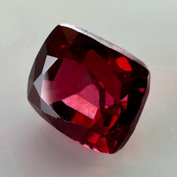 Natural cushion cut red spinel from Burma, exhibiting a rare raspberry color and excellent clarity, ideal for fine jewelry and gemstone collections.